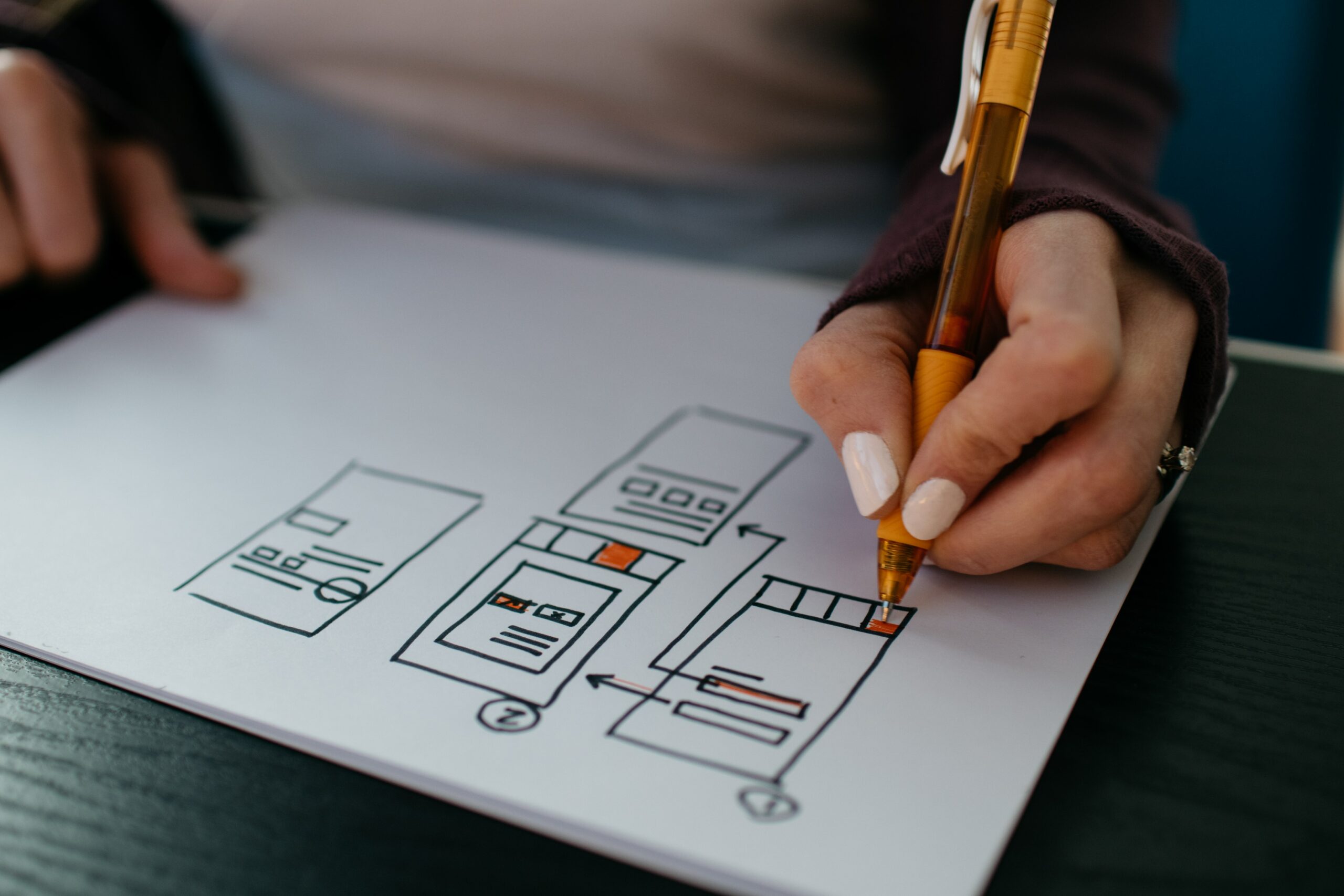 a-women-is-drawing-spme-wireframes-for-a-mobile-app-design